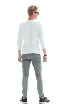 rear view. young man standing in front of white wall . isolated on white