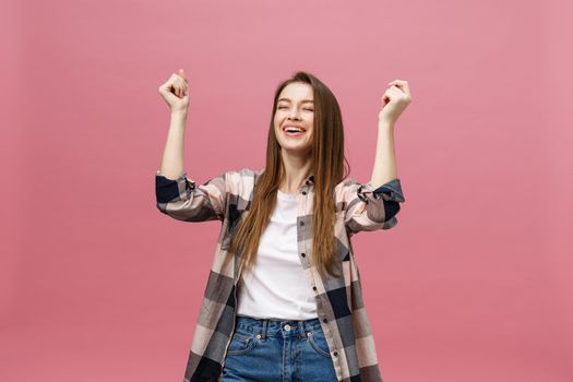 Happy successful young woman with smiling,shouting and celebrating success over pink background.