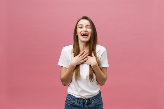 Happy successful young woman with smiling,shouting and celebrating success over pink background.