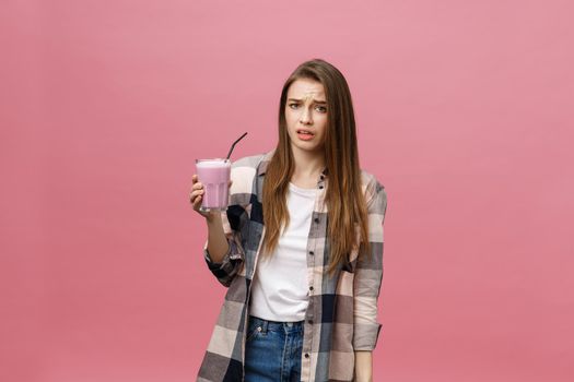 Disappointed young woman drinking smoothie juice. Isolated portrait