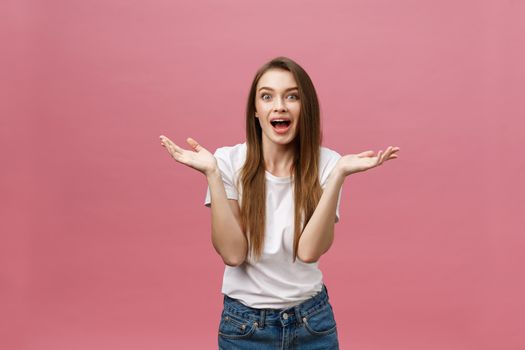 Surprised happy beautiful woman looking in excitement. Isolate over pink background and copy space