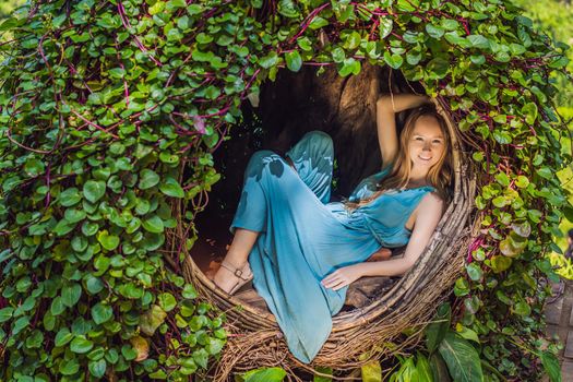 Bali trend, straw nests everywhere. Young tourist enjoying her travel around Bali island, Indonesia. Making a stop on a beautiful hill. Photo in a straw nest, natural environment. Lifestyle.