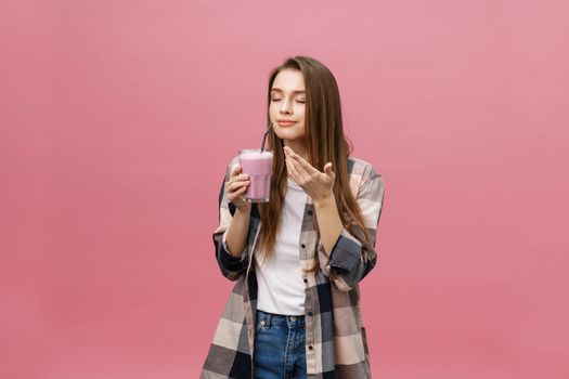 Young woman drinking juice smoothie with straw. Isolated studio portrait