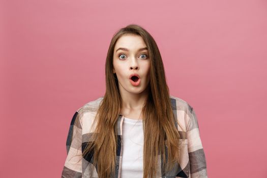 Surprised happy beautiful woman looking in excitement. Isolate over pink background and copy space