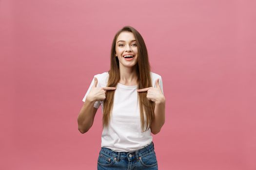 Woman pointing finger at camera and toothy smiling. Expression emotion and feelings concept. Studio shot, isolated on pink background.