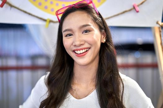 Portrait of a lesbian woman in her twenties smiling at the camera in a shopping mall