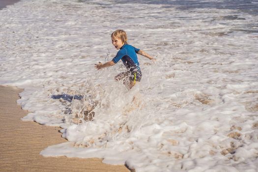 Cute little boy having fun on tropical beach during summer vacation.