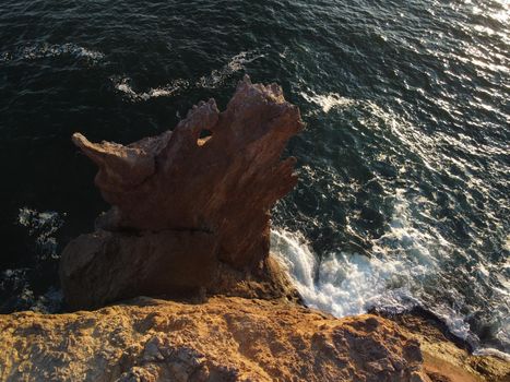 The rock or lava formation with the shape of a large animal or dragon head arise from the water. Popular travel destination volcanic rock formation in the shape of a dragon's head. Crimea, Fiolent