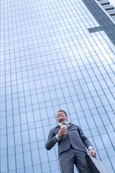 modern business man standing near a tall office building. photo with copy space