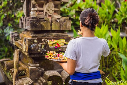 Balinese woman makes an offering to the gods.
