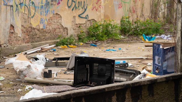 Contamination of the environment by humans. Plastic box of old TV, cardboard box for air conditioner units, trash