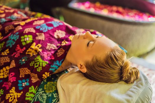 Young beautiful relaxing woman getting spa massage of shoulder in beauty salon.