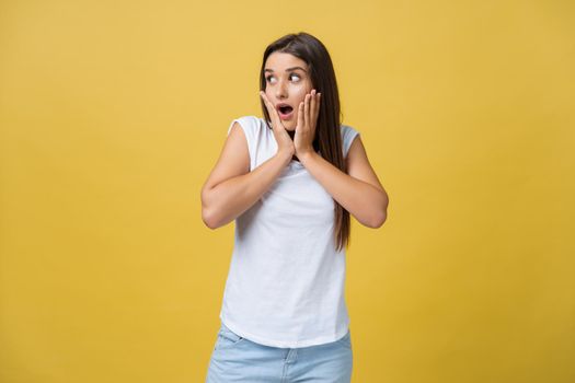 Surprised teenage girl show shocking expression with something. Isolated on Bright Yellow Background. Copy space.