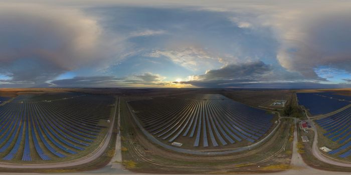 Aerial top view of a solar panels power plant. Photovoltaic solar panels at sunrise and sunset in countryside from above. Modern technology, climate care, earth saving, renewable energy concept