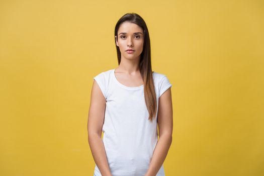 Portrait of young teenage girl with healthy skin wearing striped top looking at camera with serious or pensive expression. Caucasian woman model with beautiful face posing indoors.