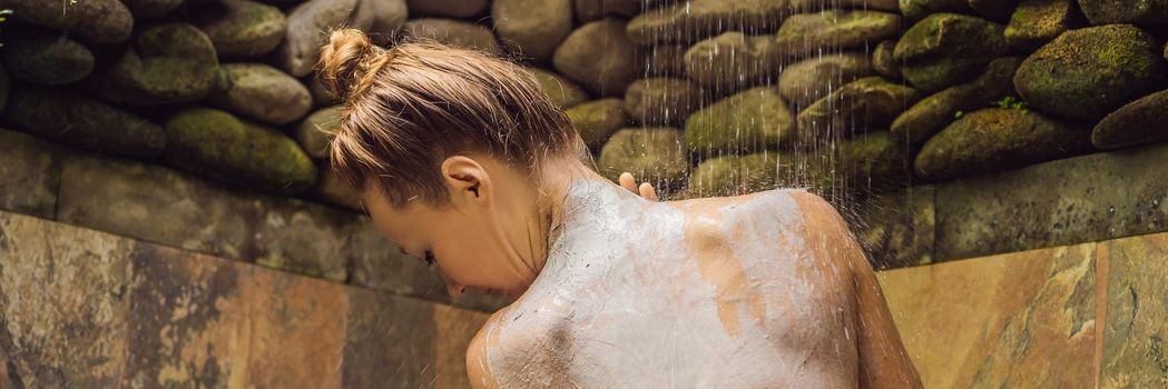 Back view of beautiful naked young woman taking shower in bathroom. BANNER, LONG FORMAT