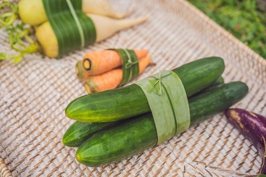 Eco-friendly product packaging concept. Vegetables wrapped in a banana leaf, as an alternative to a plastic bag. Zero waste concept. Alternative packaging.