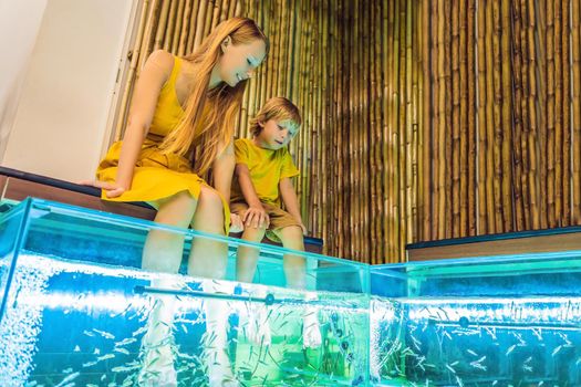 Mom and son at the fish spa. BANNER, LONG FORMAT