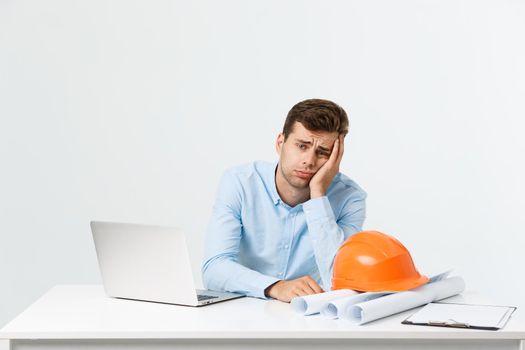 Young man wearing architect outfit and helmet with angry face, negative dislike emotion. Angry and rejection concept.
