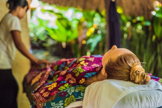 Young beautiful relaxing woman getting spa massage of shoulder in beauty salon.