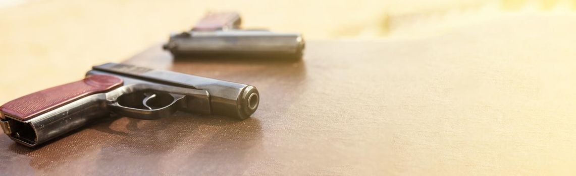 The gun lies on a table on old village boards, legalization of weapons. Crime problems. Weapons for sports and self-defense. Conceptual of violence, homicide, crime and burglary.