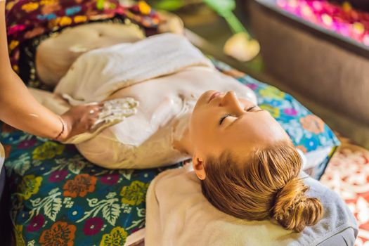 Young beautiful relaxing woman getting spa massage of shoulder in beauty salon.