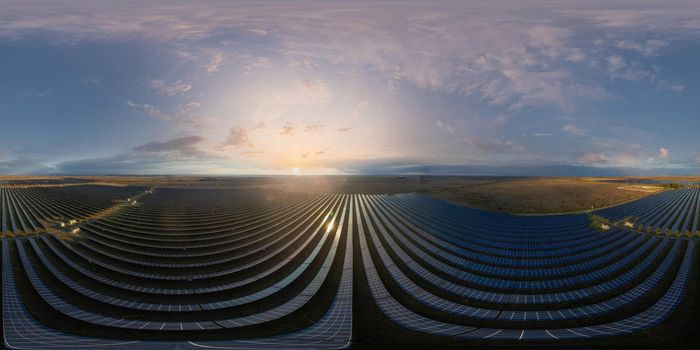 Aerial top view of a solar panels power plant. Photovoltaic solar panels at sunrise and sunset in countryside from above. Modern technology, climate care, earth saving, renewable energy concept