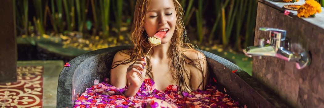 Attractive Young woman in bath with petals of tropical flowers and aroma oils. Spa treatments for skin rejuvenation. Alluring woman in Spa salon. Girl relaxing in bathtub with flower petals. Luxury. BANNER, LONG FORMAT