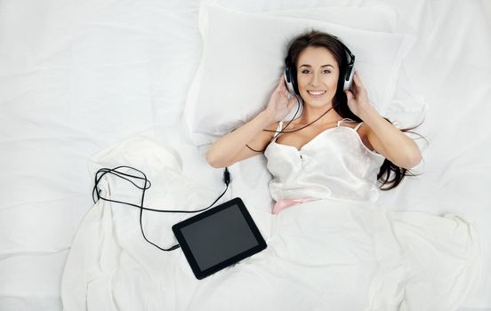 Woman lying in bed with her tablet PC