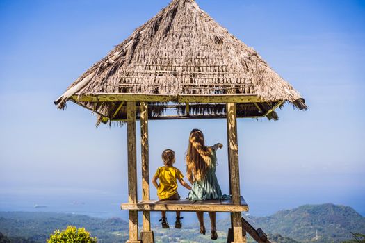 Mom and son in a gazebo in Bali. Traveling with kids concept. Kids Friendly places.