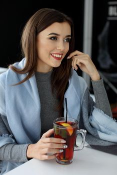 young woman holding a cup of hot mint tea or hot lemonade