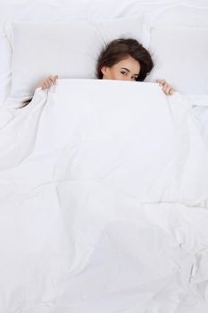 Young beautiful woman waking up in her bed fully rested. Healthy lifestyle.