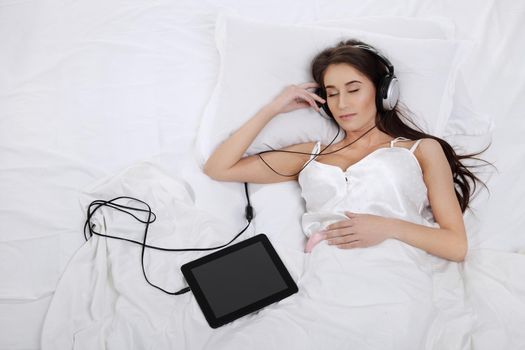 Woman lying in bed with her tablet PC