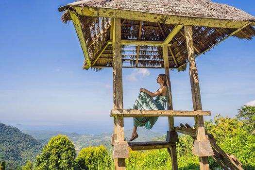Young woman in traditional balinese gazebo. Bali island.