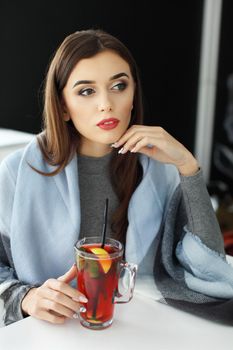 young woman holding a cup of hot mint tea or hot lemonade