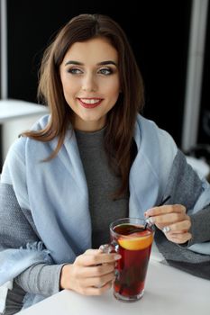 young woman holding a cup of hot mint tea or hot lemonade