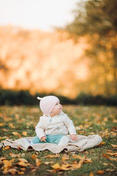 A little girl child in the autumn park smiles, spends time. Beautiful autumn background