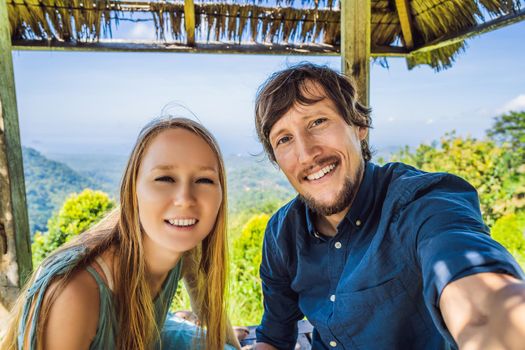 Young man and woman in traditional balinese gazebo. Bali island.