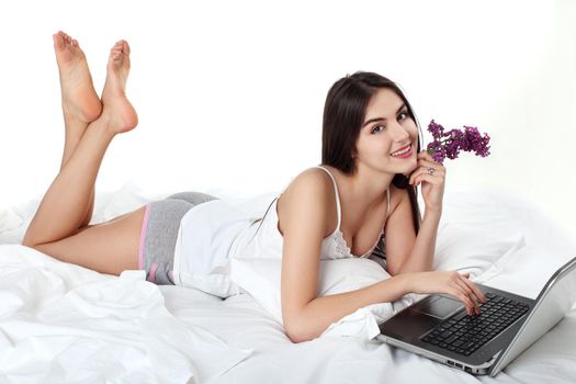 Attractive female relaxing with her laptop while on bed