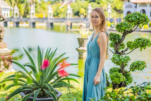 Young woman in dress in Water Palace Soekasada Taman Ujung Ruins on Bali Island in Indonesia. Amazing old architecture. Travel and holidays background.