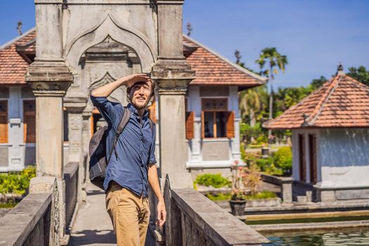 Young man in Water Palace Soekasada Taman Ujung Ruins on Bali Island in Indonesia. Amazing old architecture. Travel and holidays background.
