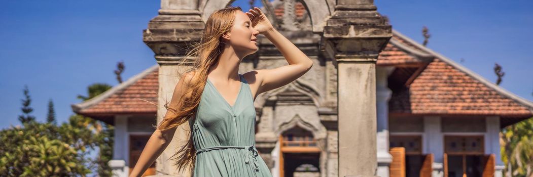 Young woman in dress in Water Palace Soekasada Taman Ujung Ruins on Bali Island in Indonesia. Amazing old architecture. Travel and holidays background. BANNER, LONG FORMAT