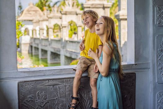 Mom and son in Water Palace Soekasada Taman Ujung Ruins on Bali Island in Indonesia. Amazing old architecture. Travel and holidays background. Traveling with kids concept. Kids Friendly places.