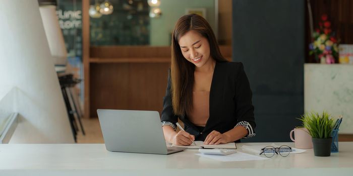 A portrait of Asian happy Businesswoman smiling and working at office.