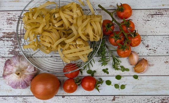 top view cooking ingredients with noodles, tomatoes , eggs and spices