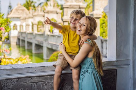 Mom and son in Water Palace Soekasada Taman Ujung Ruins on Bali Island in Indonesia. Amazing old architecture. Travel and holidays background. Traveling with kids concept. Kids Friendly places.