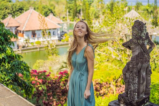 Young woman in dress in Water Palace Soekasada Taman Ujung Ruins on Bali Island in Indonesia. Amazing old architecture. Travel and holidays background.