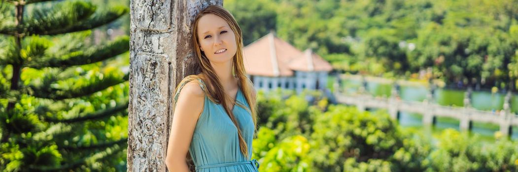 Young woman in dress in Water Palace Soekasada Taman Ujung Ruins on Bali Island in Indonesia. Amazing old architecture. Travel and holidays background. BANNER, LONG FORMAT