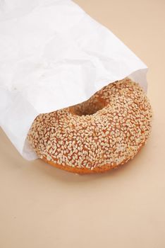 fresh bagel bread in a paper on table ,