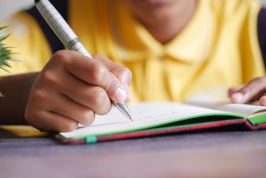 child hand writing on notepad .